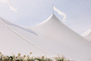 White sailcloth tent wedding venue with flowing peaks and floral details