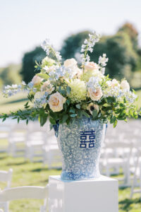 Blue and white floral arrangement displayed at an outdoor wedding ceremony