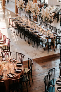 Wedding reception tables styled with neutral linens, tapered candles, and modern floral arrangements