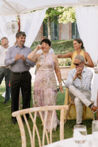 Mother of the bride being honored during the wedding reception as guests look on emotionally