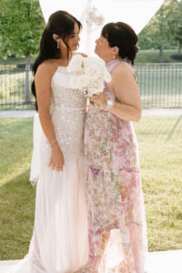 Mother of the bride being honored during the wedding reception as guests look on emotionally